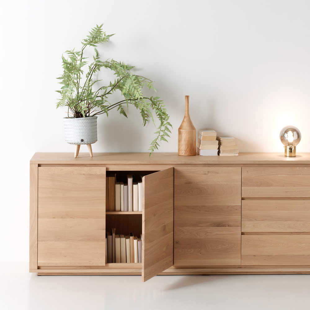 Dressoir ZEN in eikenhout met openstaand deurtje, boeken en plant.
