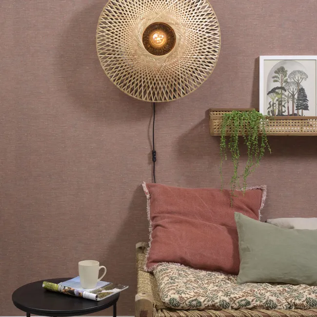 Wandlamp Kalimantan Naturel/Zwart, gemaakt van bamboe, boven een bankje of zitmeubel.