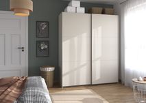 Crèmekleurige AURELIO schuifdeurkast met Artisan eik afwerking, staand in een moderne slaapkamer.