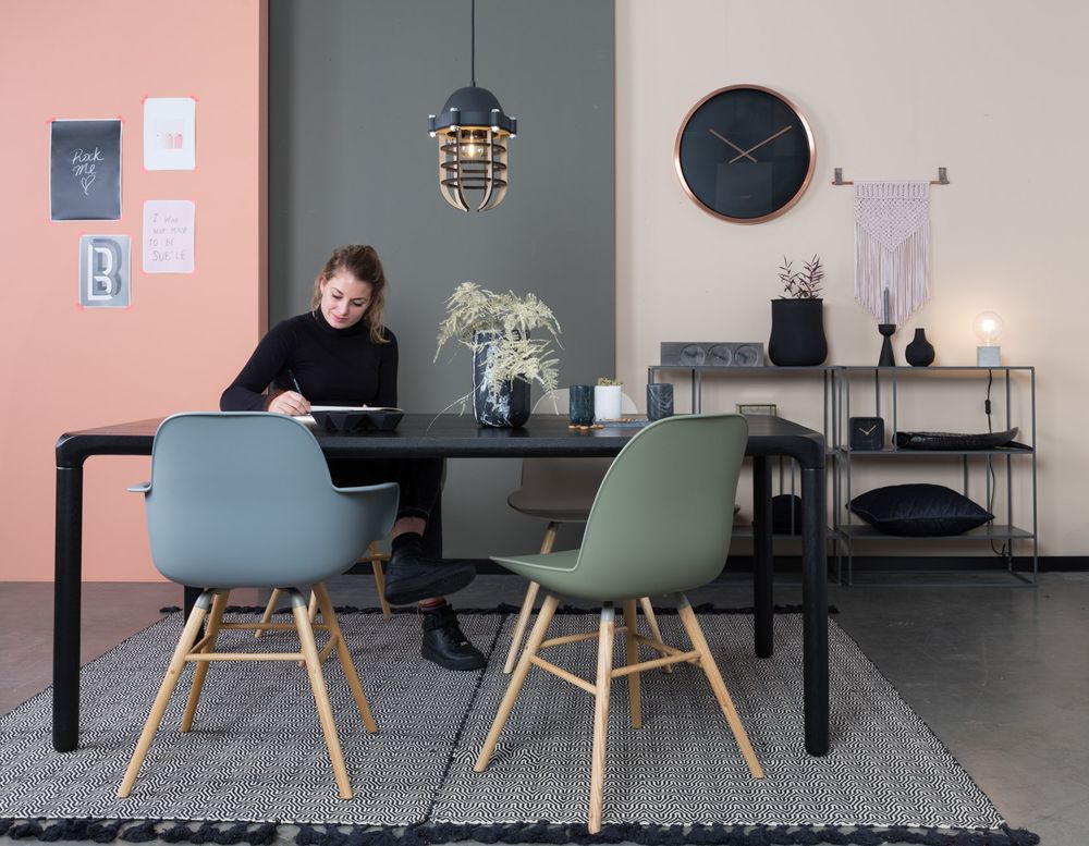 Zwart metalen eetkamertafel STORM, met houten onderstel en twee gekleurde kunststof stoelen.