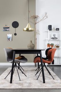Uitschuifbare tafel GLIMPS van zwart hout met zwarte stoelpoten.