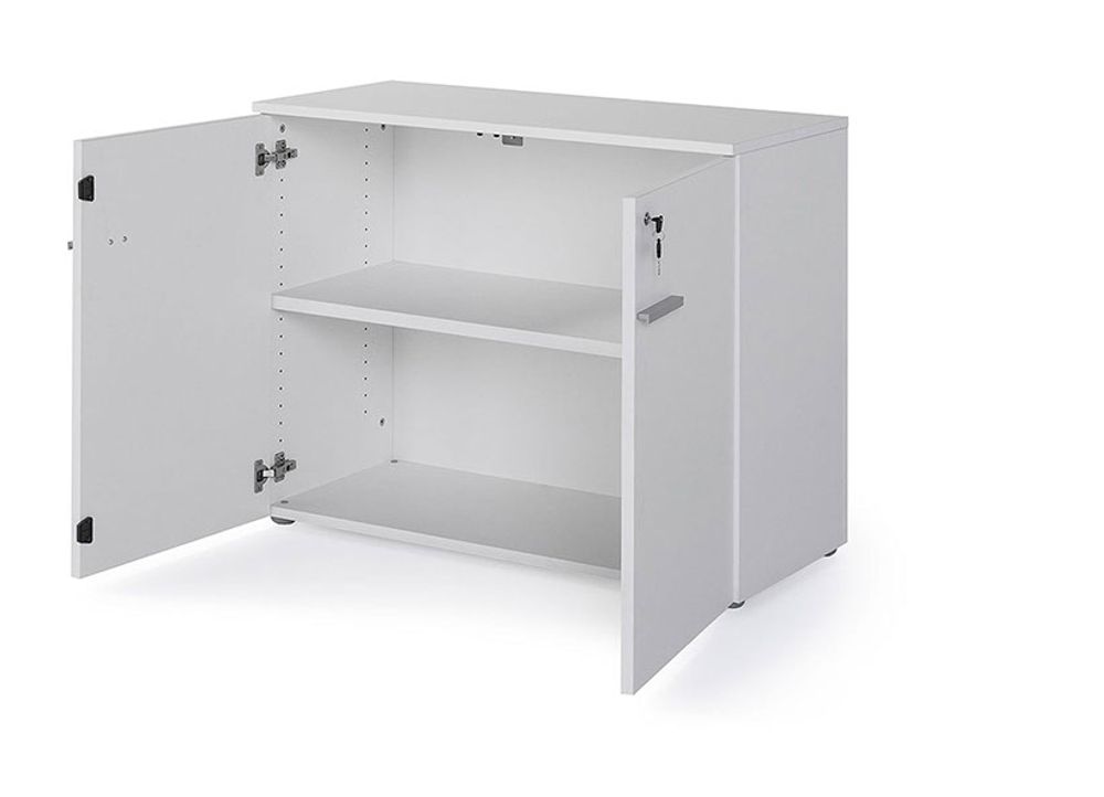 Lage witte melamine kast met twee deuren en twee verstelbare planken, rechter deur op slot.