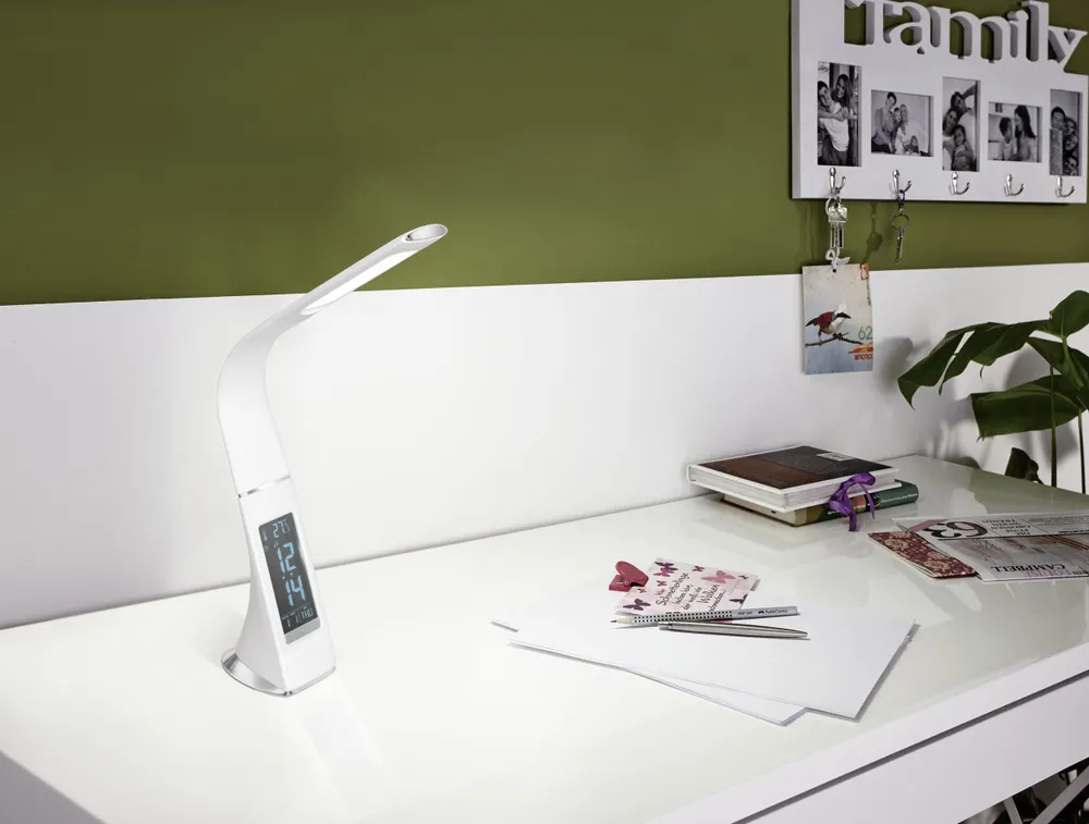 Witte plastic tafellamp Cognoli met klok en verlicht display op een glanzend bureau.