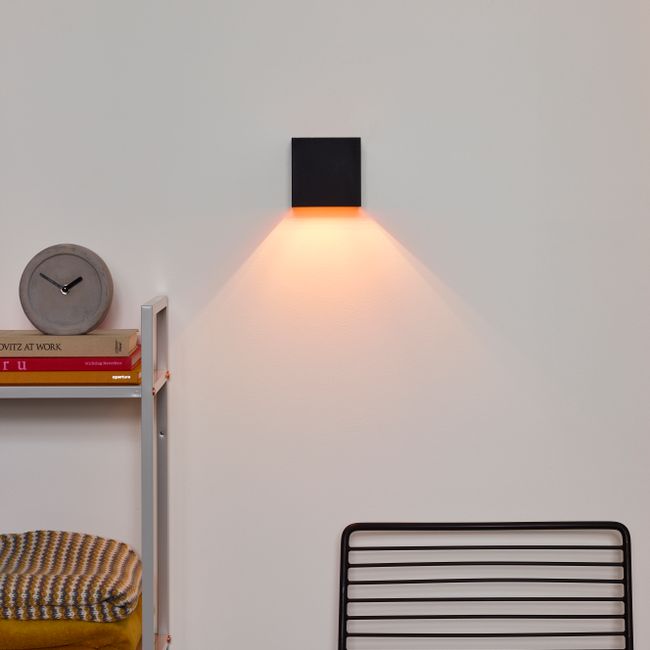 Wandlamp XIO van aluminium, grijs, met warm licht naar beneden schijnend.