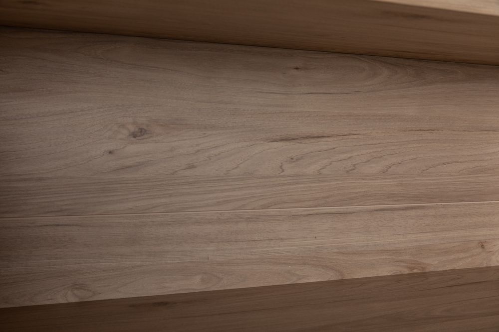 Detail van een eikenhouten plank in een boekenkast met nerven en lichte kleurschakeringen.