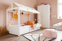 Roze knijplamp met zilverkleurige accenten aan het hoofdeinde van een kinderbed.