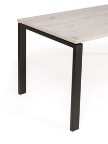 Een hoek van een bureau met een blad van licht hout en zwarte metalen poten.