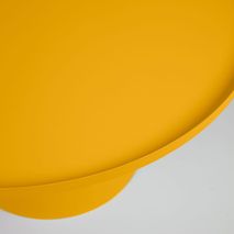 Ronde salontafel FLEKSA van mosterdgeel geverfd metaal.