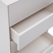 Witte houten commode Vedrana met de middelste lade opengeschoven.