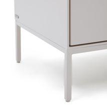 Detail van een witte Vedrana commode met slanke metalen poten.