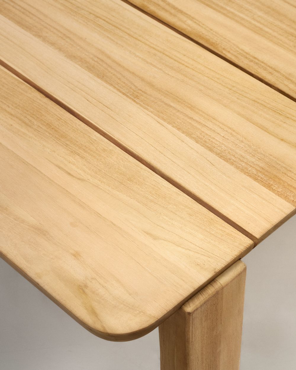 Tuintafel Icaro van lichtbruin massief teakhout met lamellenblad en afgeronde hoek.
