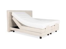 Beige elektrische boxspring met verstelbaar hoofdeinde en gestoffeerd onderstel.
