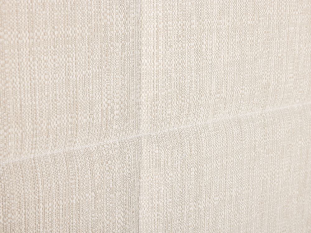 Close-up van beige stof met subtiele textuur, mogelijk voor elektrische boxspring.