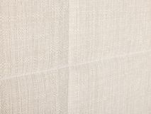 Close-up van beige stof met subtiele textuur, mogelijk voor elektrische boxspring.