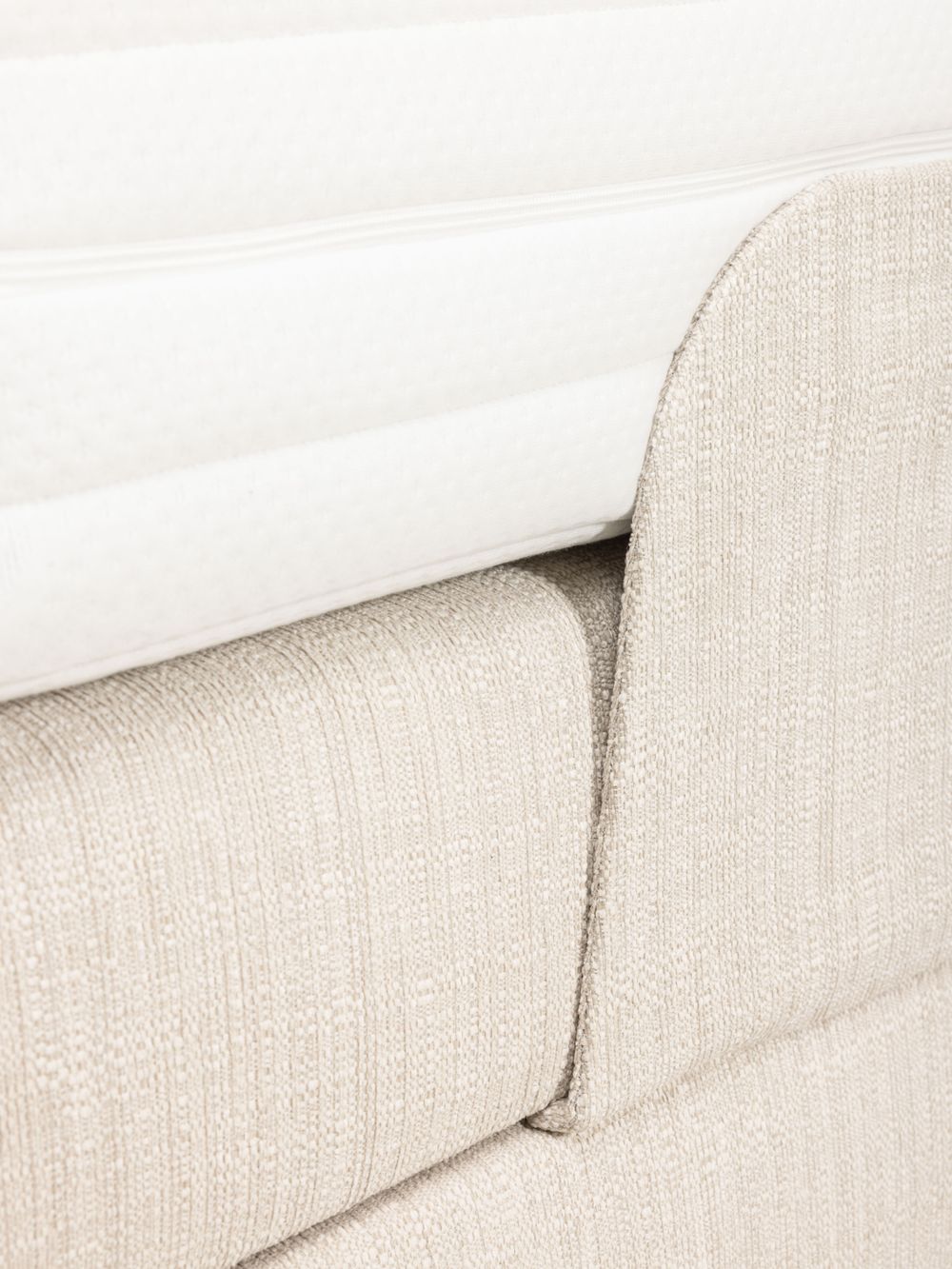 Onderkant van de matras en de geplooide stoffen hoes van de elektrische beige boxspring.