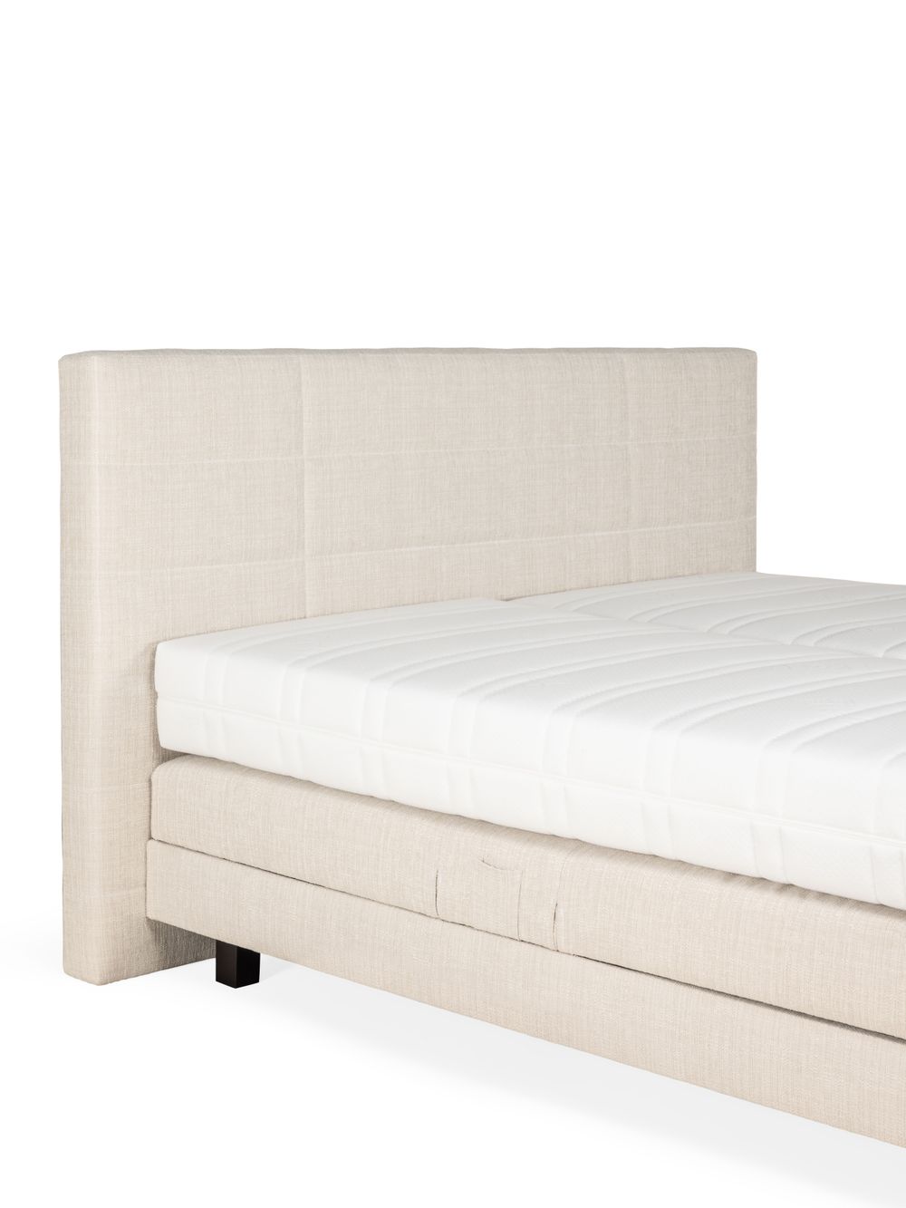 Beige elektrische boxspring met gewatteerd hoofdbord van linnen stof.