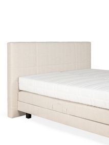 Beige elektrische boxspring met gewatteerd hoofdbord van linnen stof.