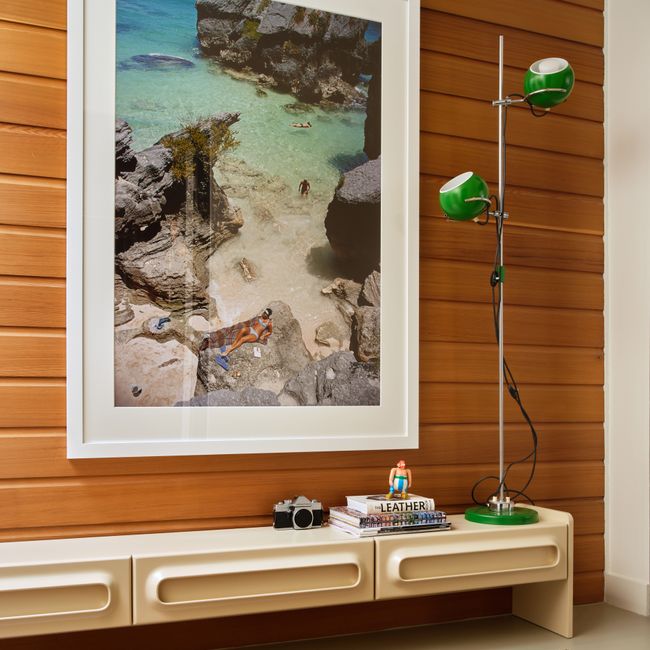 Tv-meubel SPACE crème van hout, met drie opbergvakken, voor een houten wand.