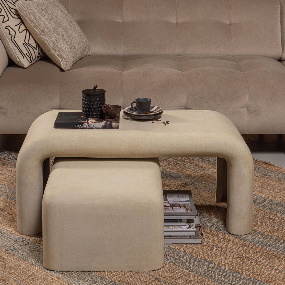 Set van 2 beige salontafels van betonlook materiaal, met een kleiner exemplaar eronder geschoven.