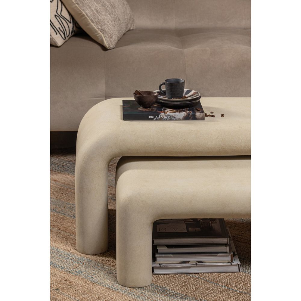 Set van 2 beige betonnen salontafels met afgeronde hoeken.