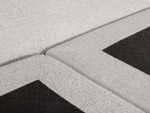 Boxspring ASPEN met beige stoffen bekleding en zwarte, gewatteerde stof details.