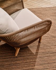 Loungefauteuil CATALINA in beige/acaciahout op een donkerbruin vloerkleed.